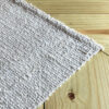 Close-up of the Solid Runner Rug showing undyed wool weave and fabric ANDINA label.