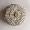 Round cushion in Beige and Natural White with comb-pattern design, shown from the front.