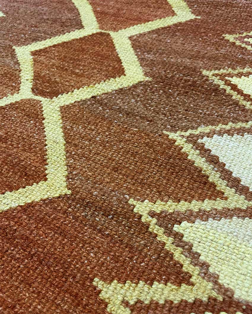 Detalle de cerca de un textil Qom tejido a mano con un diseño geométrico tradicional que presenta diferentes formas y colores.