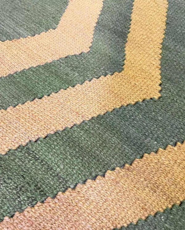 Detalle de cerca de un textil Qom tejido a mano con un diseño geométrico tradicional que presenta diferentes formas y colores.