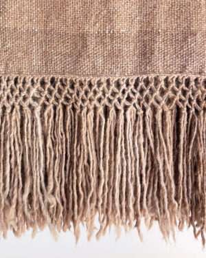 Beige llama fibre throw blanket with fringes.