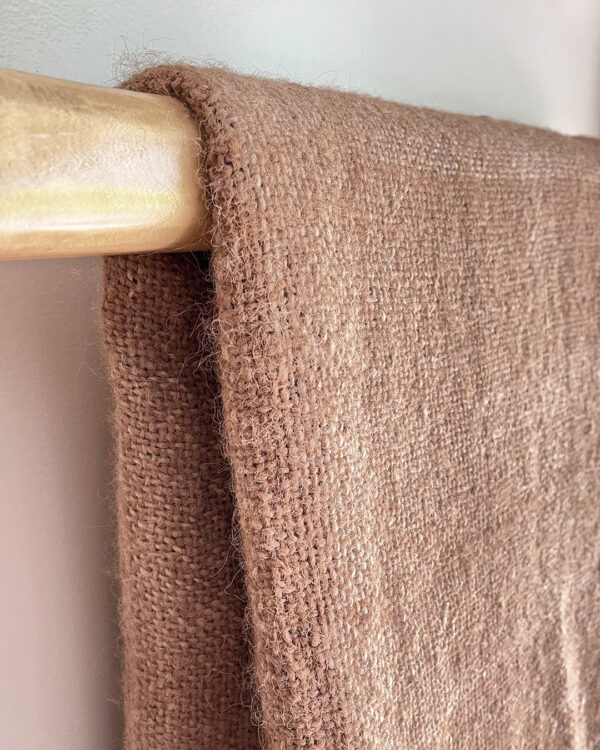 Side view of the folded Llama Throw – Oat in undyed beige llama fiber.