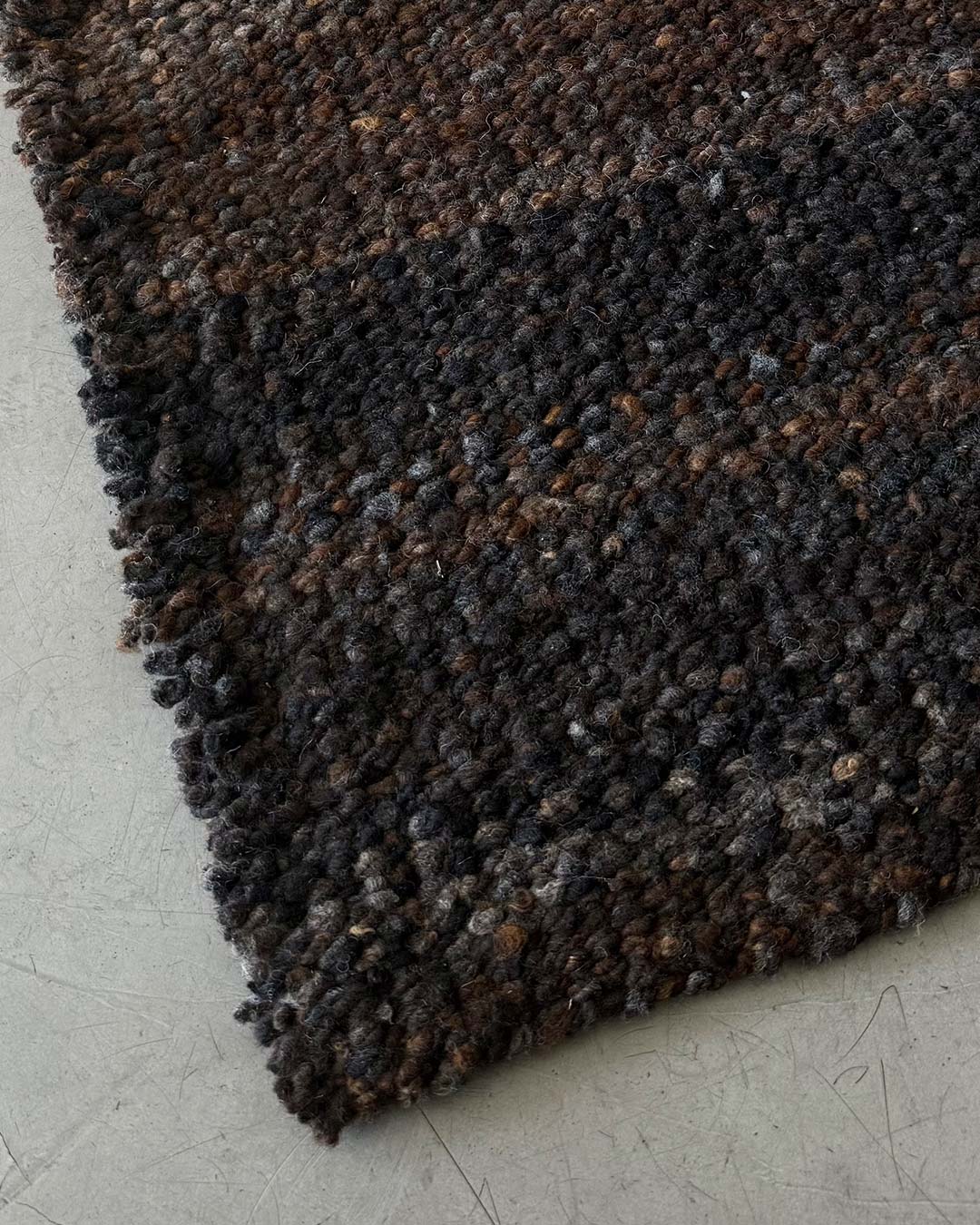 Close-up of solid coffee wool rug's corner