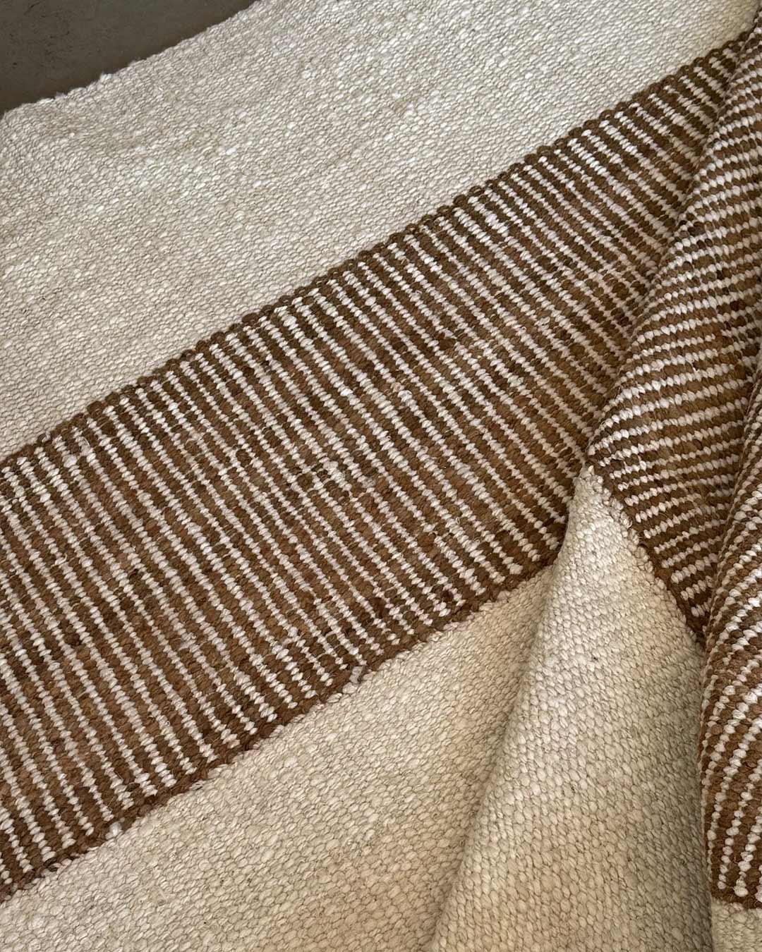 Superficie de alfombra natural y nuez con diseño rayado tejido a mano