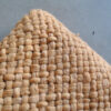 Close-up of the woven texture of the camel wool throw.