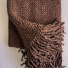 Chocolate brown wool throw partially folded, showing its reverse side and fringe.