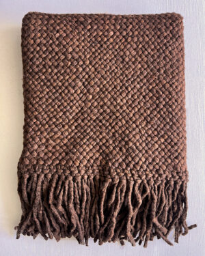 Chocolate brown handwoven wool throw with fringes, neatly folded to show texture and weave.