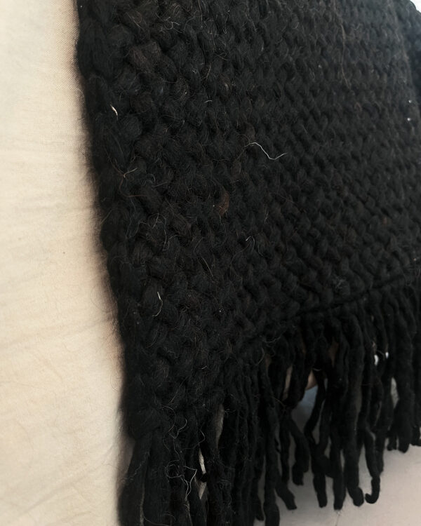 Handwoven black wool throw made from natural sheep's wool, with a close-up of its thick, textured weave.