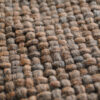 Macro image of the chocolate brown wool throw’s woven pattern and wool fibers.