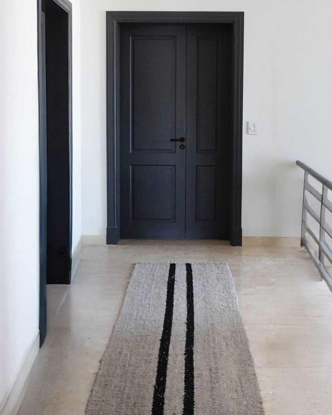 Gray and black striped wool runner rug styled in modern hallway