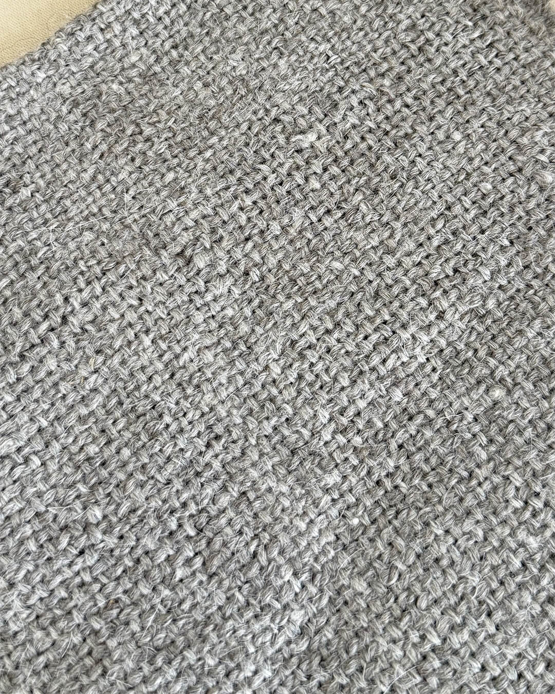 Close-up of ANDINA’s Ash llama throw showing the natural gray handwoven surface.