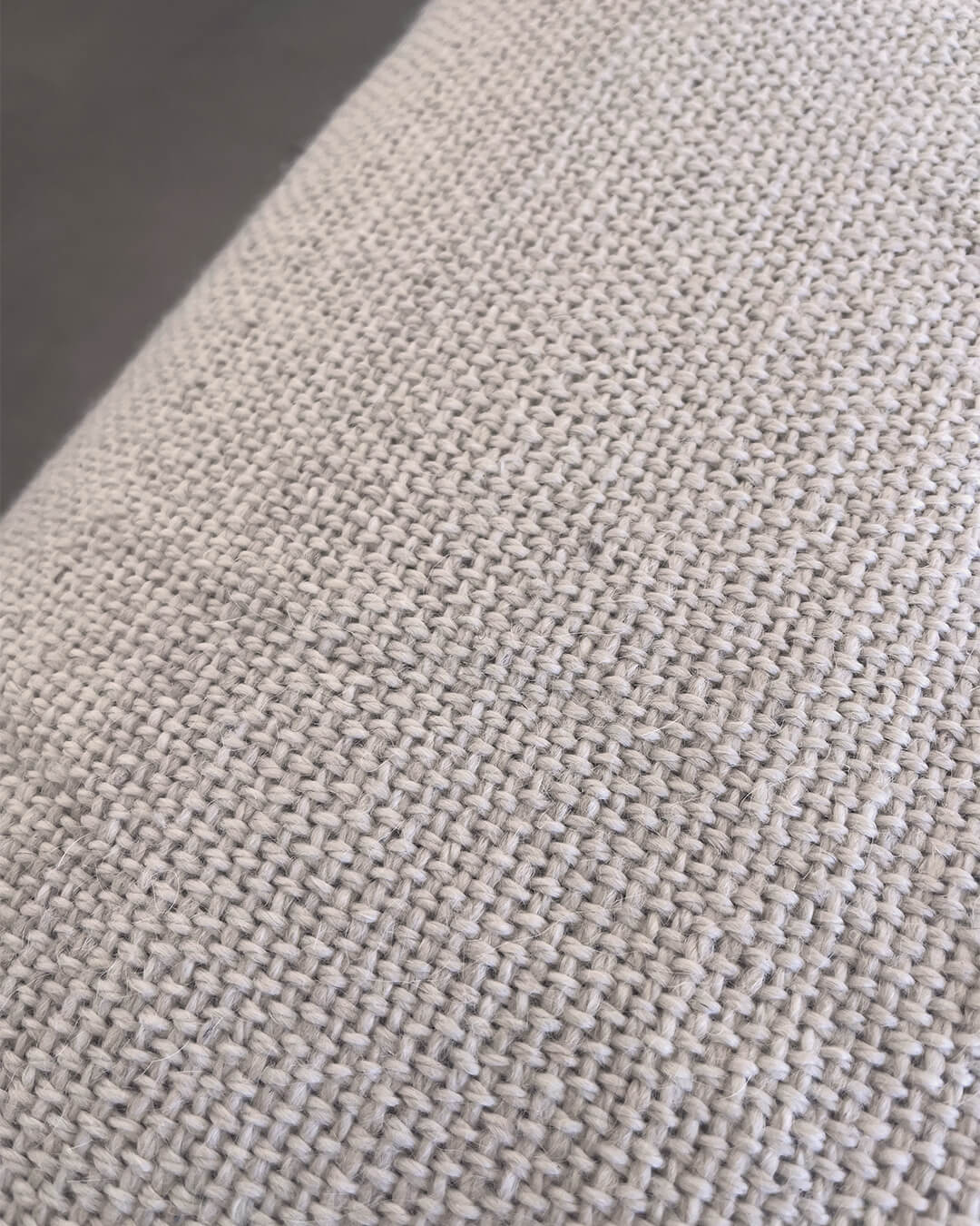 Detalle en primer plano de textura tejida a mano en fibra de llama blanco natural.