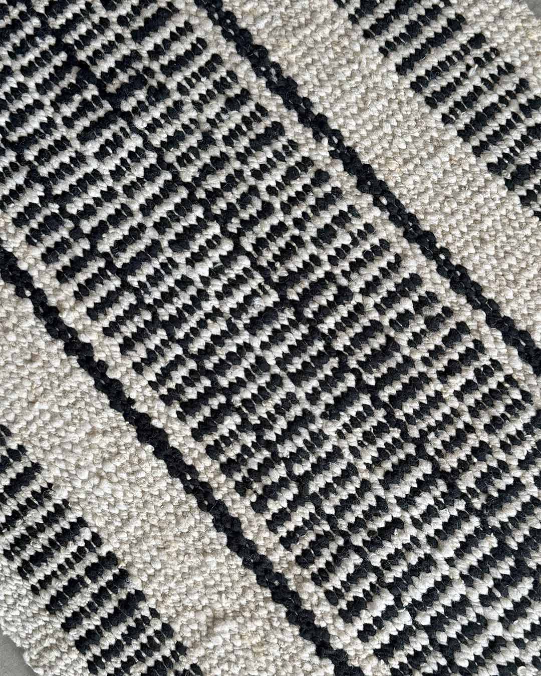 Close-up of the Quebracho runner rug weave in natural and black wool.