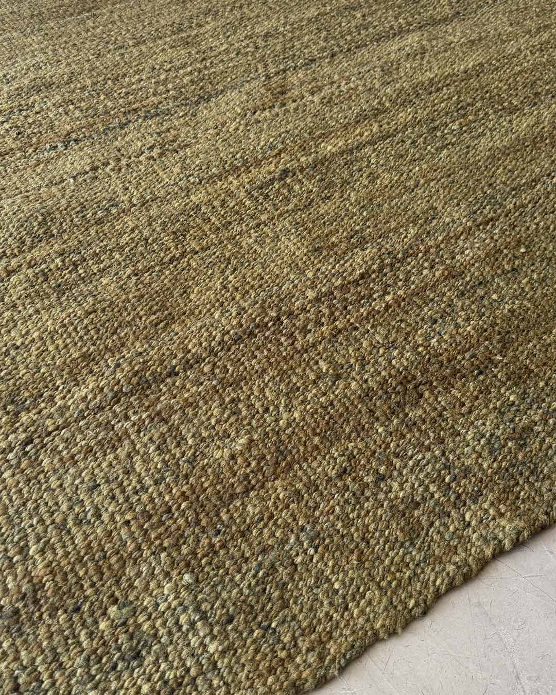 Surface of solid moss wool rug with natural tonal variation