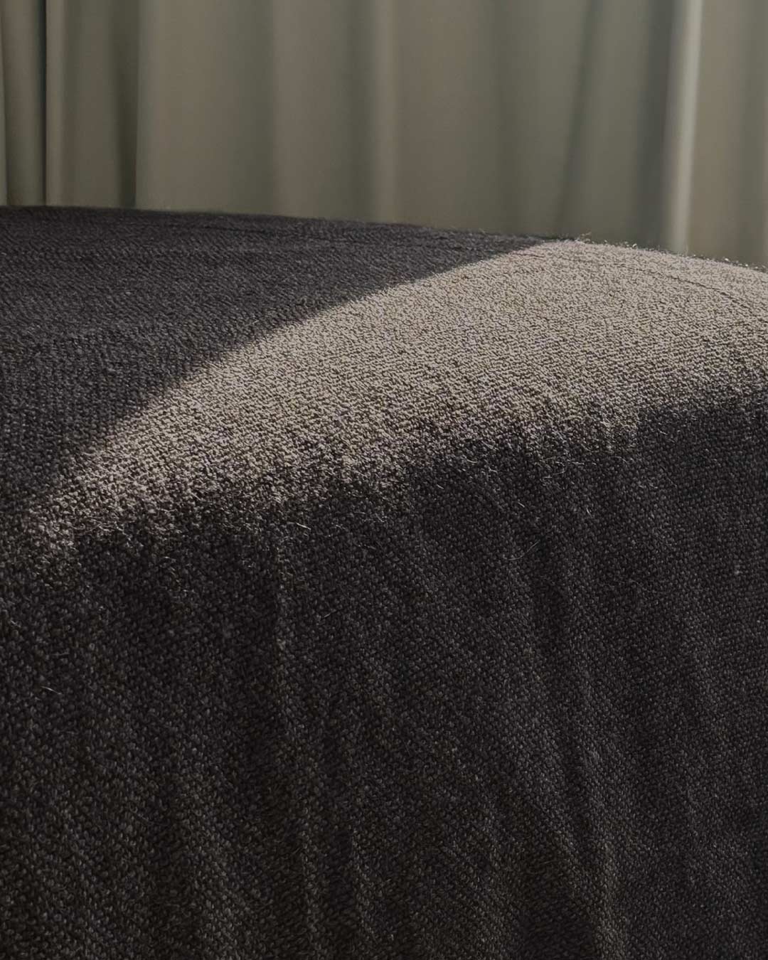 Undyed llama bed quilt black draped over bed — natural dark coat of black llamas handwoven in Argentina