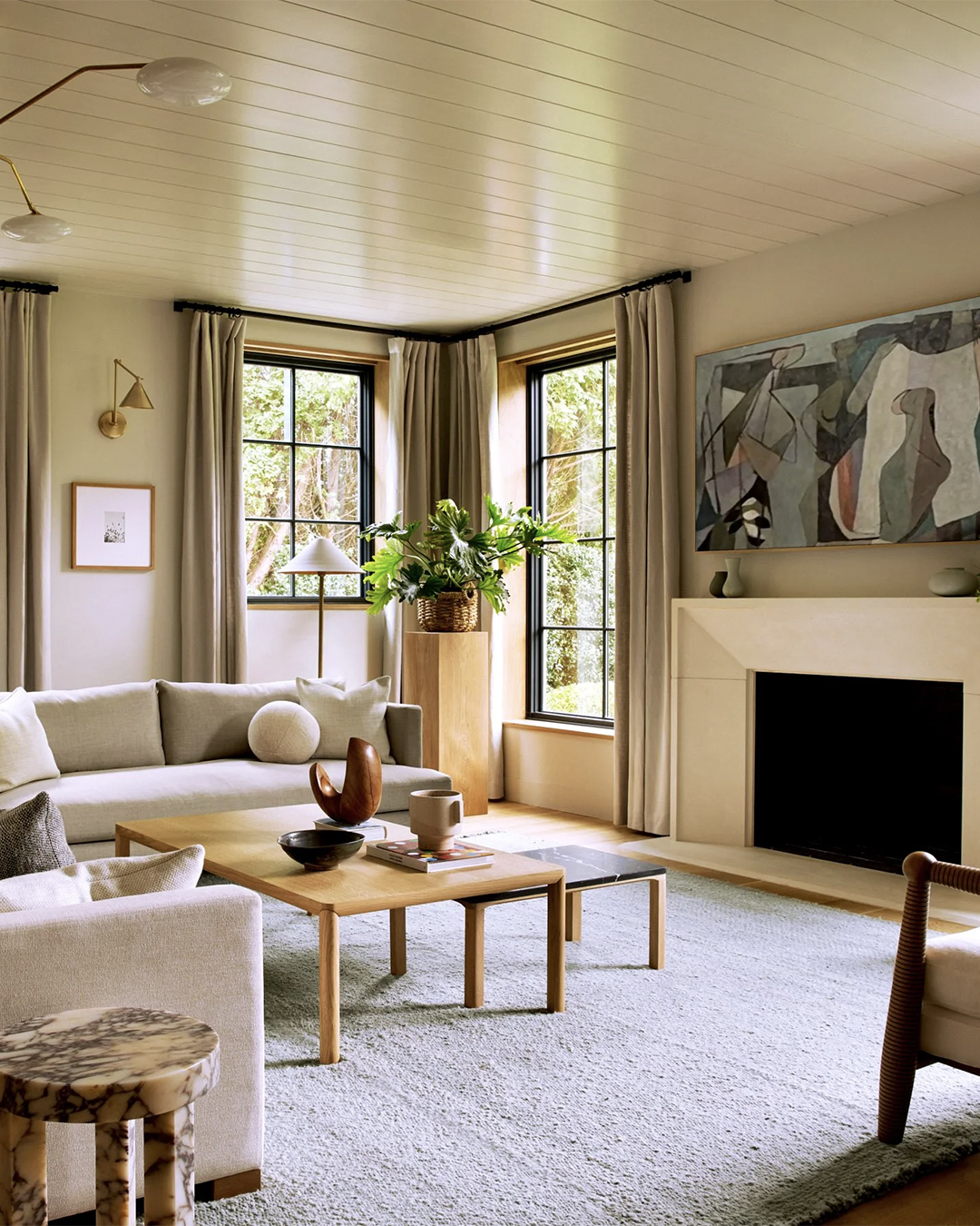 Solid blue gray wool rug in a living room with a stone fireplace and abstract painting