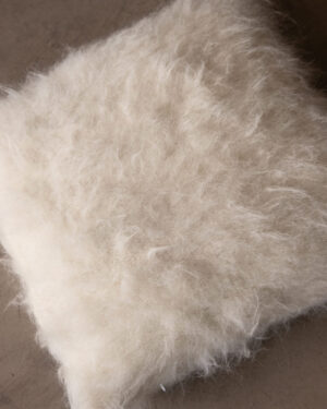 Close-up of the Natural White llama cushion’s brushed pile, showing its deep natural texture