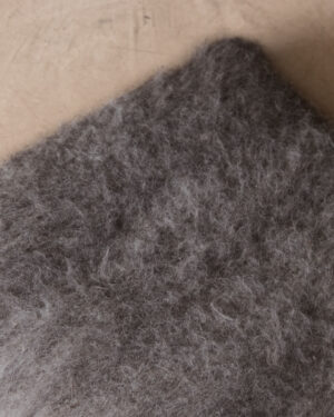 Close-up of the Shadow llama cushion’s corner showing the depth of the brushed pile